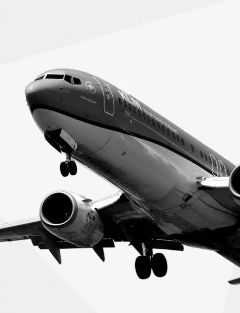 Zwart wit foto van een overvliegend KLM vliegtuig
