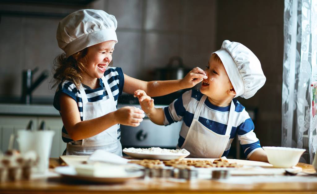 Twee kleine kinderen die samen koekjes aan het bakken zijn