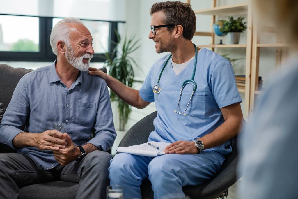 Blije dokter aan het praten met een oude man