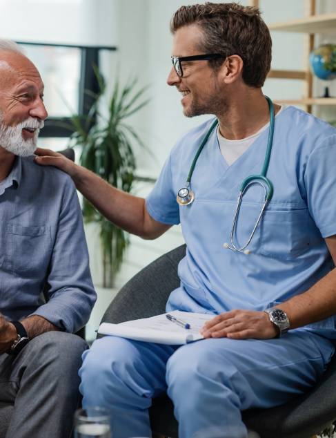 Blije dokter aan het praten met een oude man