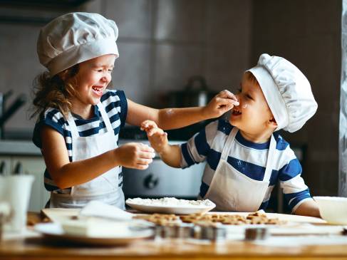Twee kleine kinderen die samen koekjes aan het bakken zijn