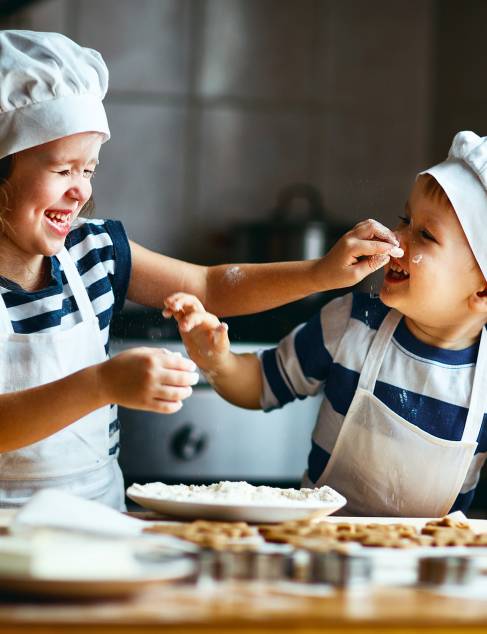 Twee kleine kinderen die samen koekjes aan het bakken zijn