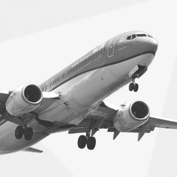 Zwart wit foto van een overvliegend KLM vliegtuig