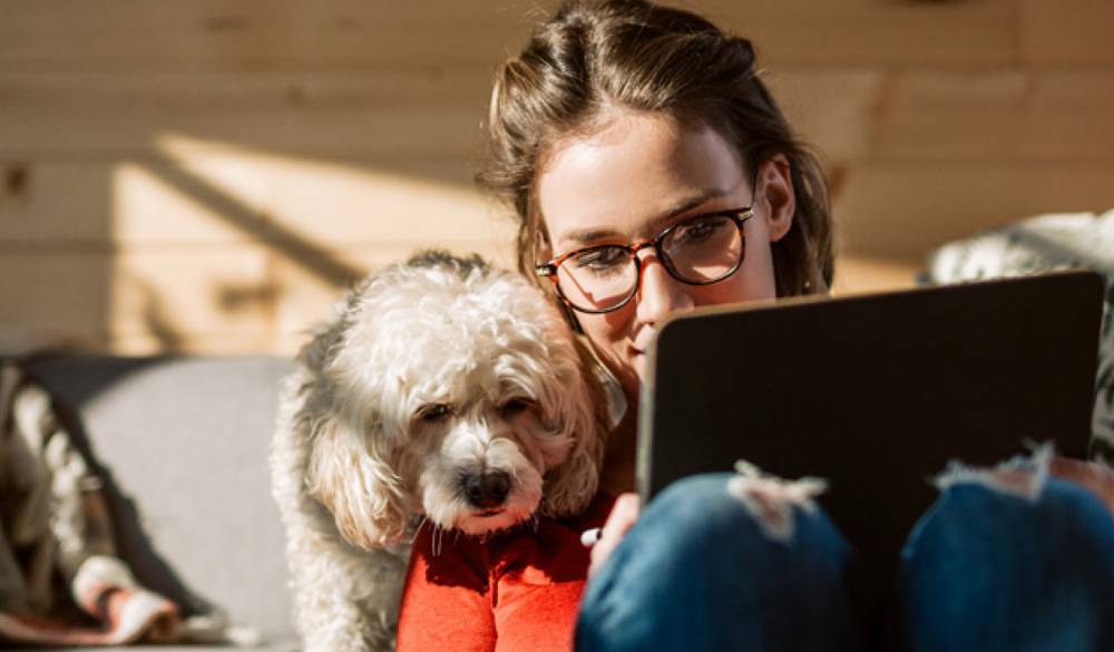 Vrouw met een hond achter een tablet